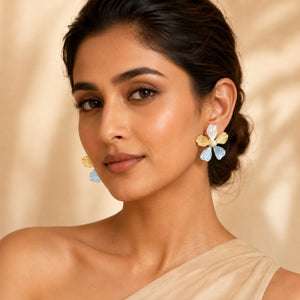 Sky blue floral pearl earrings on a dark jewellery studio display
