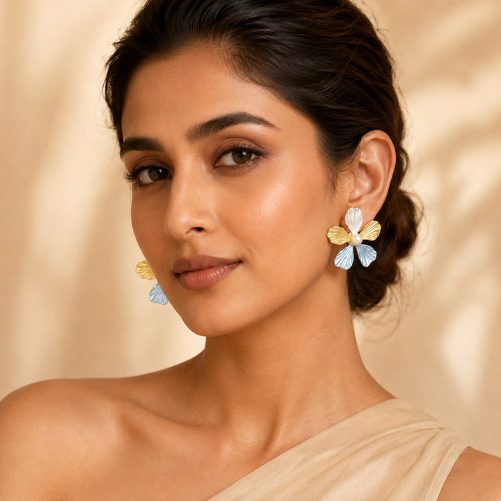 Sky blue floral pearl earrings on a dark jewellery studio display