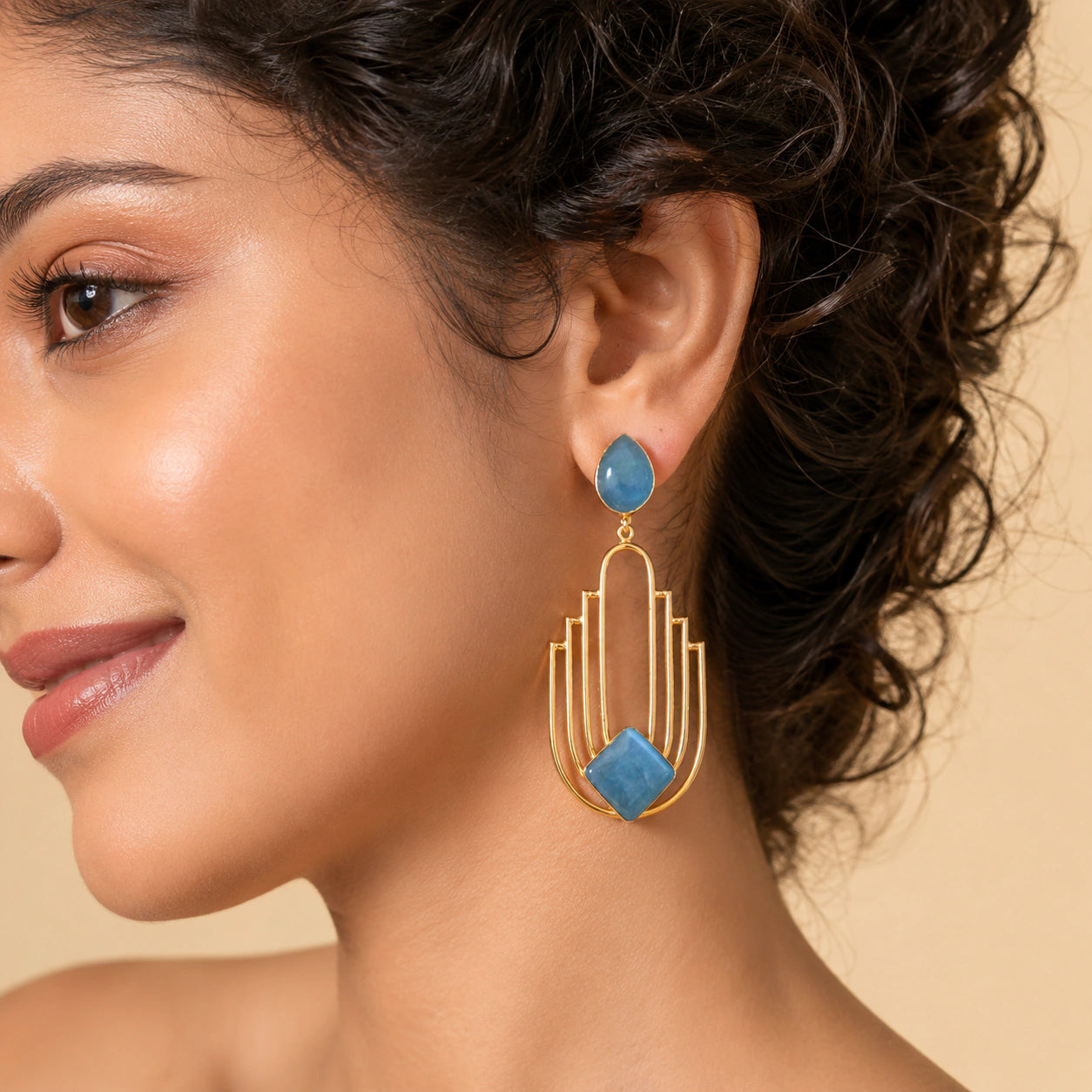 Angled view of sky blue gold geometric chandelier earrings