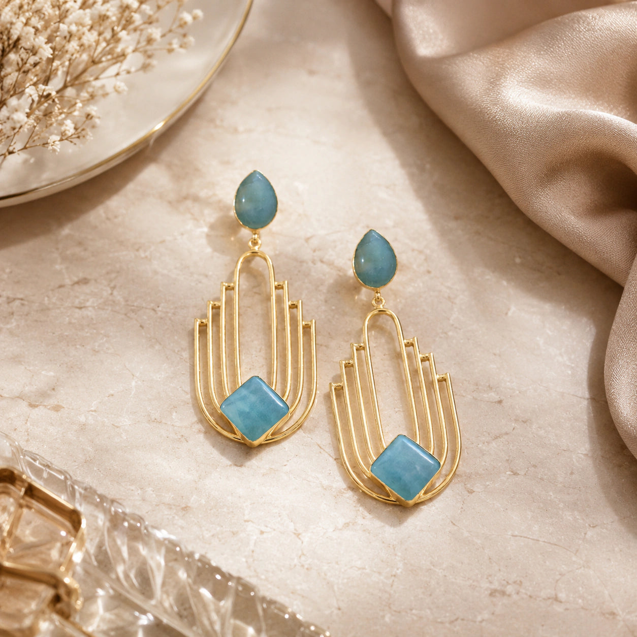 Sky blue chandelier earrings styled in a modern jewellery flat lay